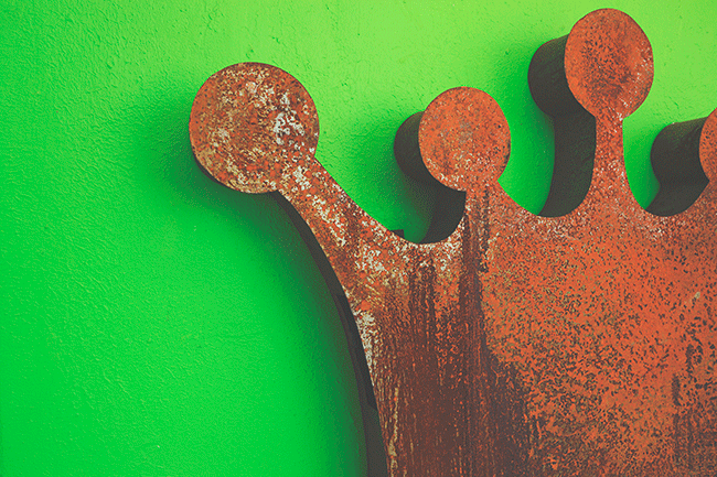 metal crown on green background