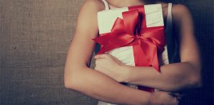 girl holding present with big red ribbon